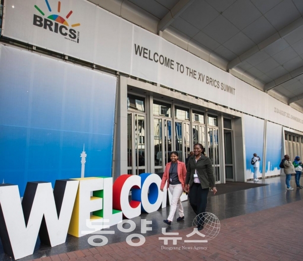 [신화통신=동양뉴스] 지난 20일(현지시간) 행인들이 '제15차 브릭스(BRICS) 정상회의'가 열리는 남아프리카공화국 요하네스버그 샌튼 컨벤션센터 앞을 지나고 있다.