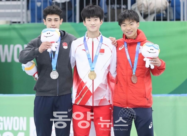 쇼트트랙 스피드 스케이팅 남자 1천m에서 금메달을 획득한 중국 선수 장신저(가운데), 은메달을 목에 건 튀르키예 선수 무하메드 보즈다그(왼쪽), 동메달을 딴 일본 선수 라이토 키다가 지난 21일 기념사진을 찍고 있다.